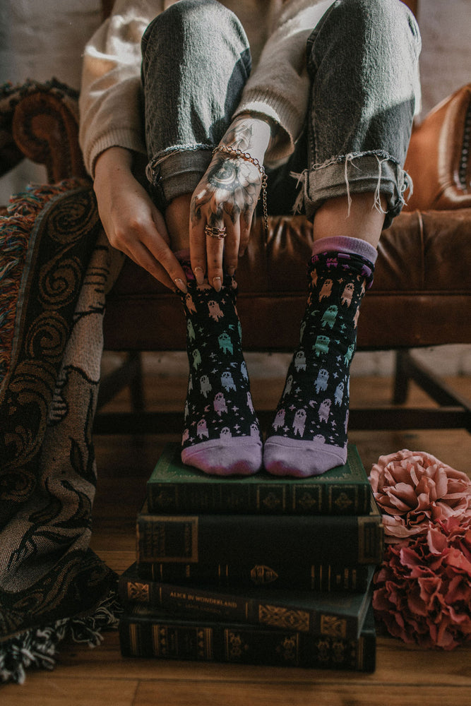 A woman wearing whimsical rainbow ghost printed socks. 