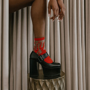 A woman wearing red flame socks with high heels. 