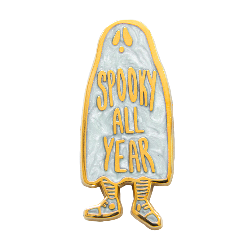 A "Spooky All Year" ghost enamel pin plated with 18k gold with pearl enamel. Hard enamel design.