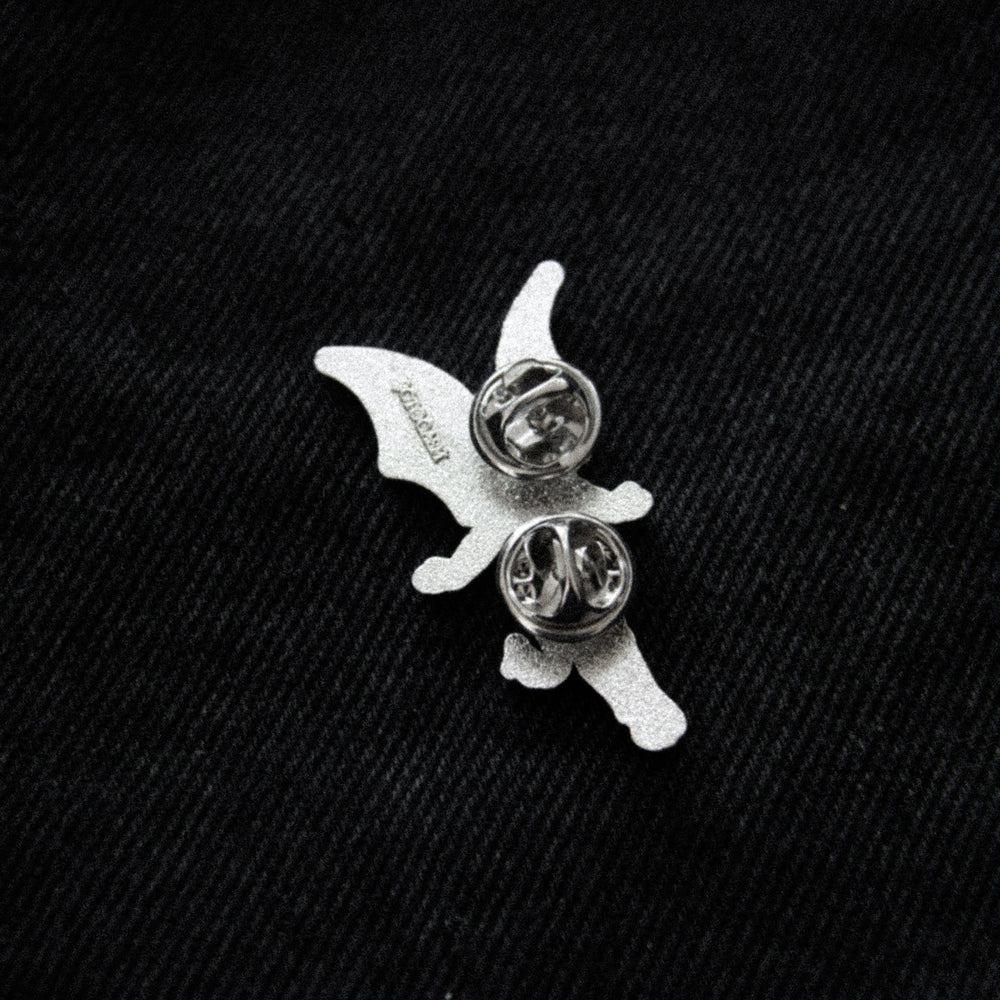 A gothic black and silver enamel pin of a dark fairy. 