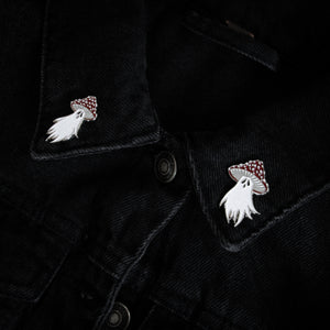 Witch, dark style brooches on the lapels of a black denim jacket. 