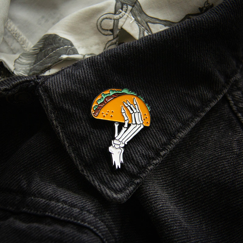 A funny fashion accessory enamel pin featuring cool artwork of a taco.