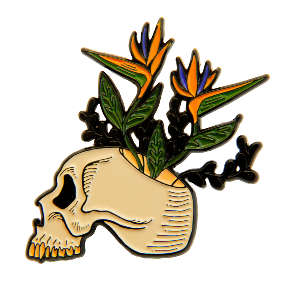 A cool enamel pin of  a skull with tropical flowers growing out of it.