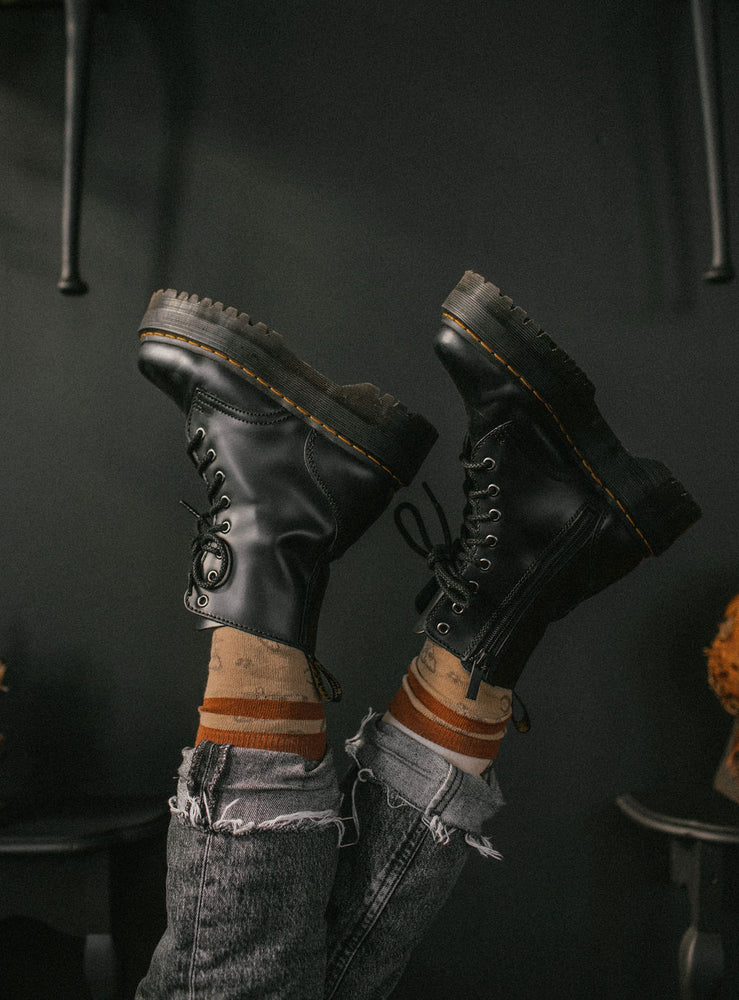 Combat boots worn with burnt orange and brown socks.