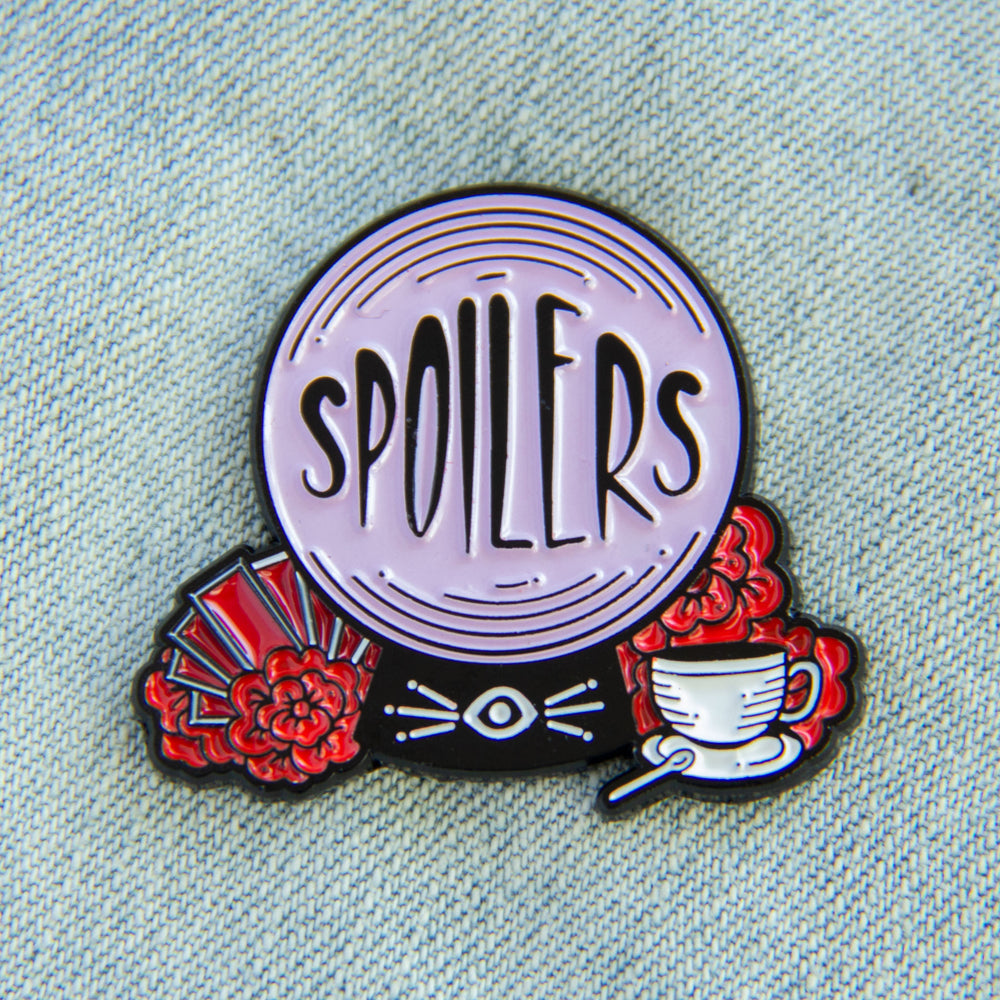 A funny enamel pin of a crystal ball with the quote, "Spoilers". 