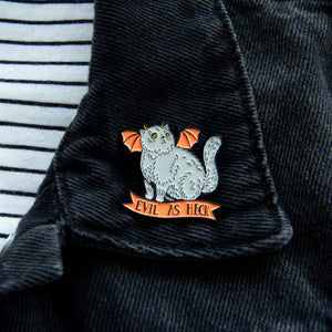 A spooky cat pin on the lapel of a black denim jacket. 
