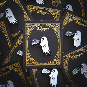 A funny goth enamel pin of a black and white ghost with boobs. Designed by Ectogasm.