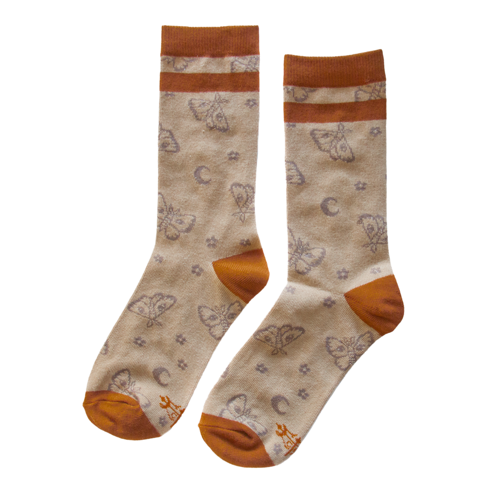 Cute warm toned socks in orange and beige featuring a print of moths and moons. 