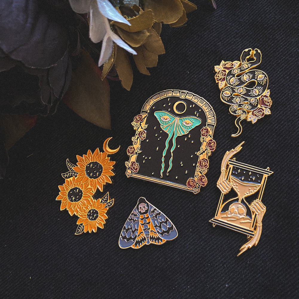 A collection of gold Ectogasm enamel pins featuring spiritual symbols.