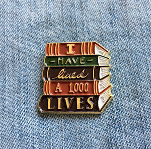 "I Have Lived A Thousand Lives" book enamel pin in gold. 
