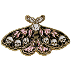 A witchy black and pink enamel pin of a moth with skulls on its wings. 