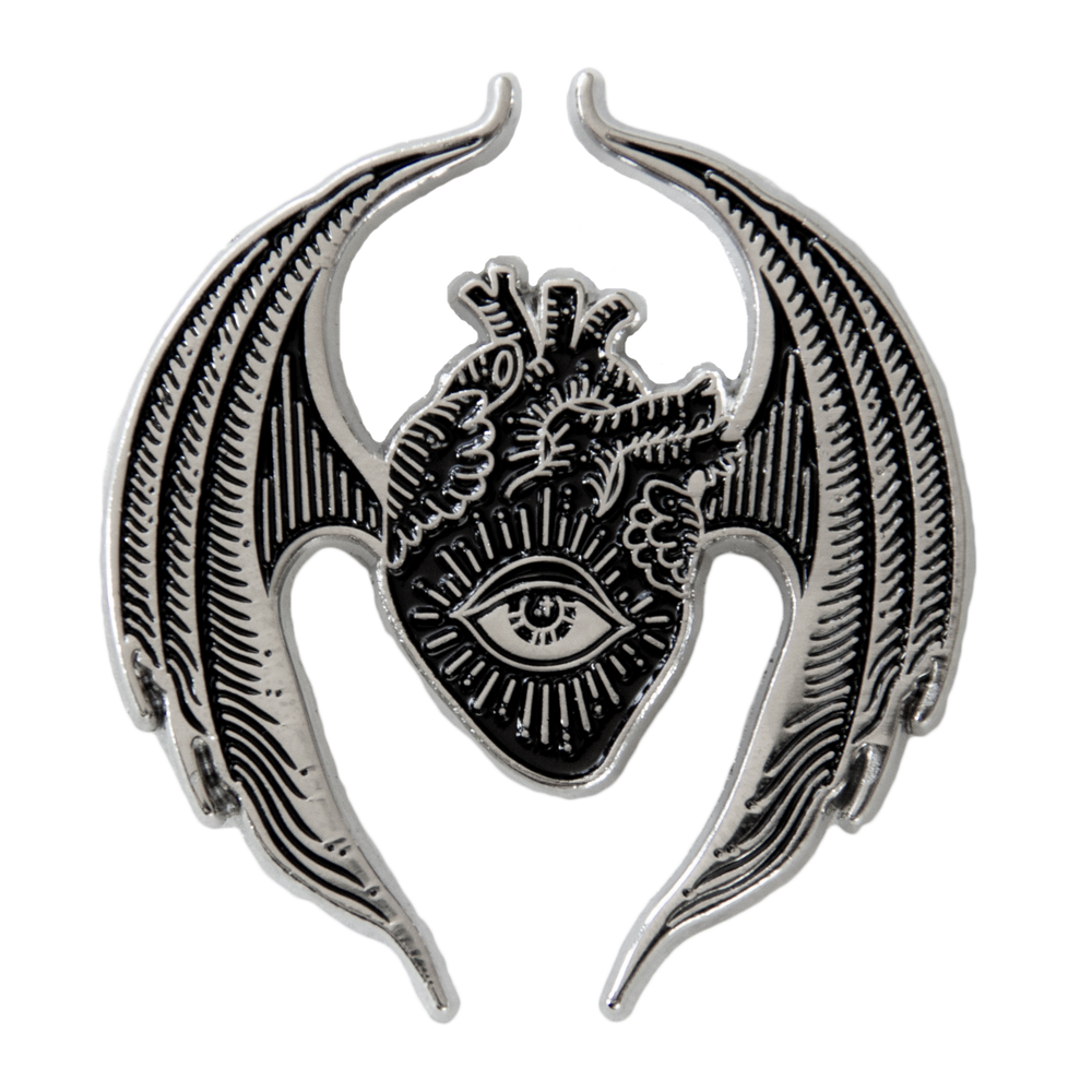 A gothic style brooch featuring an oddities and curiosities inspired design of an anatomical heart with bat wings and an all seeing eye. 
