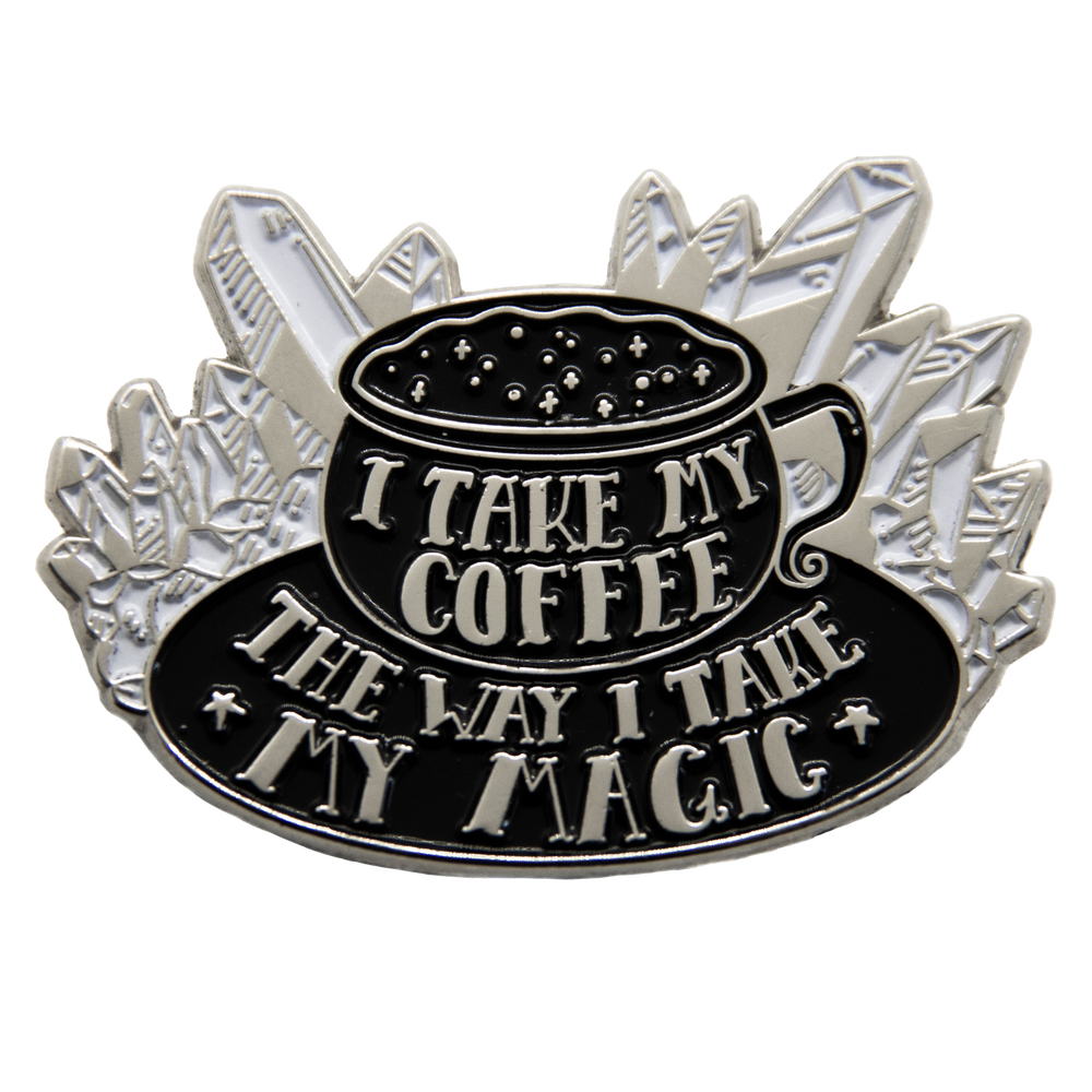 A witchy enamel pin of a cup of coffee with the quote, "I take my coffee the way I take my magic."