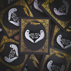 A funny enamel pin of two ghosts holding a heart with the quote, "You're Never Alone If You Have Demons".