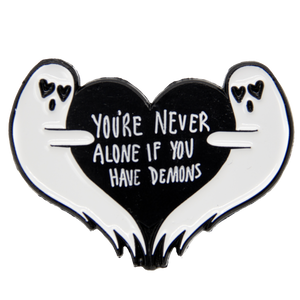 A funny dark humor enamel pin of two ghosts with a black heart and the quote, "You're Never Alone If You Have Demons"