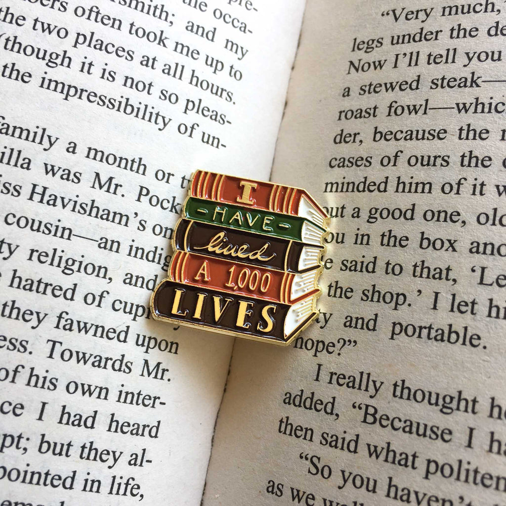 A literary themed lapel pin inside of a book. 