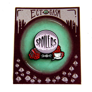 A spooky enamel pin of a crystal ball with a funny quote and red flowers. 