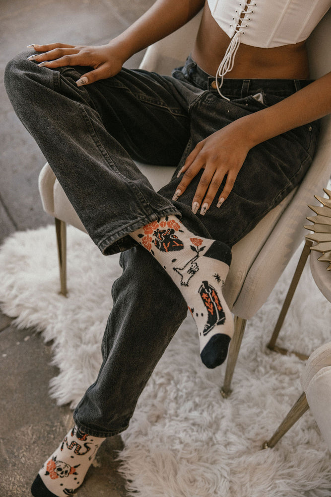 Cool tattoo western themed socks with snakes, skulls, stars, cowboy boots, and roses for alternative fashion. 