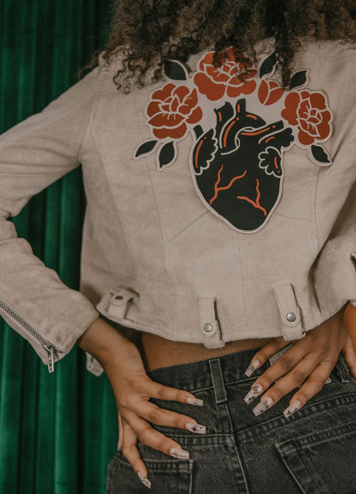 A backpatch of an anatomical heart blooming roses for cool alternative fashion. 