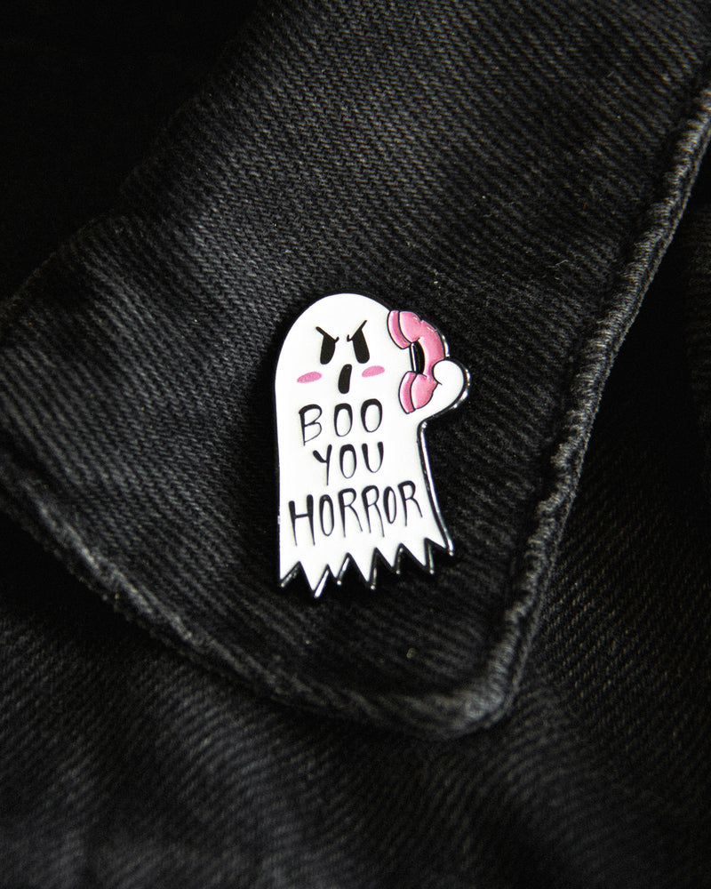 A cute ghost enamel pin with the nostalgic movie quote, "boo you whore". 