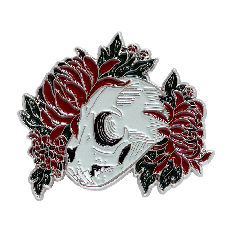 A witch aesthetic enamel pin of a cat skull with flowers. 