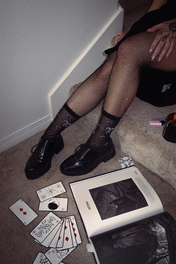 Women's black sheer socks with heart pattern for alternative fashion and a witch aesthetic.