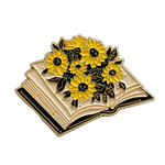 A cute enamel pin of an open book blooming with sunflowers. 