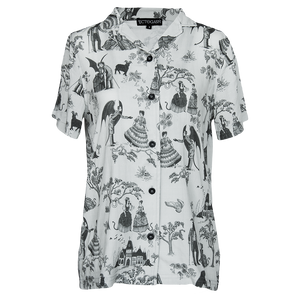 A women's gothic fashion button down shirt with a witchy toile pattern printed on it in light gray and black.