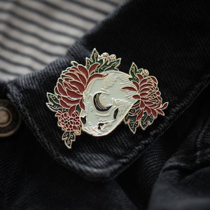 An alternative fashion lapel pin of an animal skull with red flowers for gothic style. 