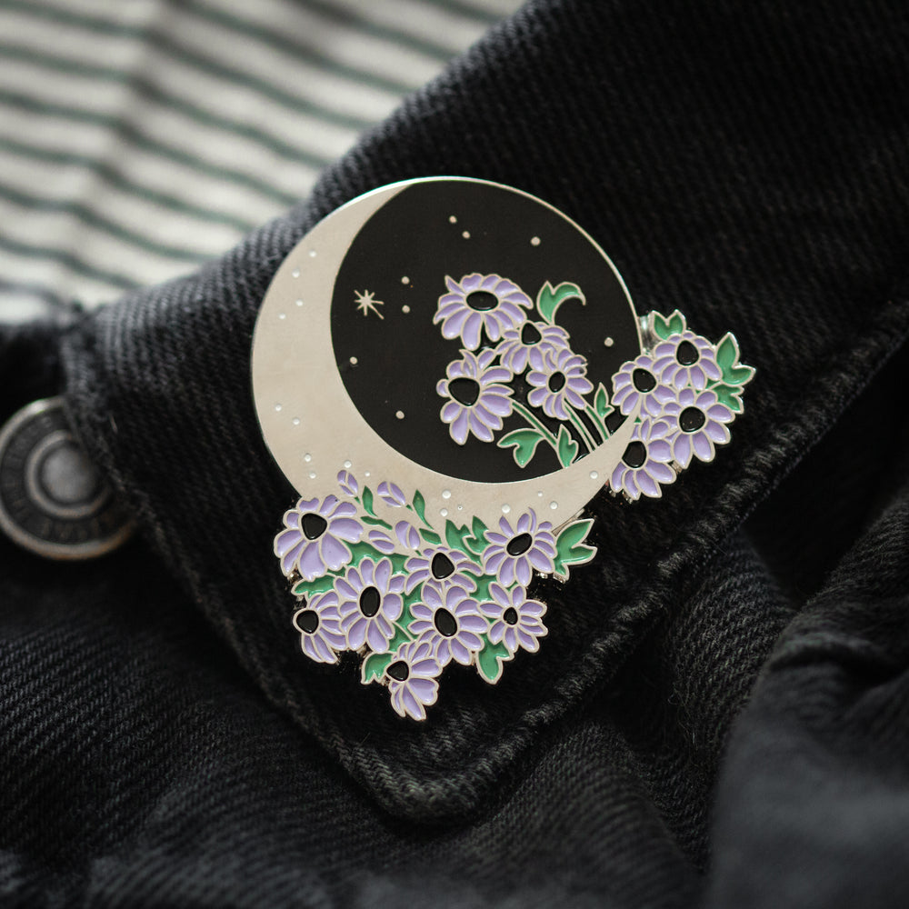 A celestial botanical enamel pin of the moon with flowers. 