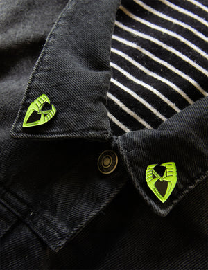 
            
                Load image into Gallery viewer, Glow-in-the-dark vampire teeth enamel pins on the collar points of a jacket. 
            
        