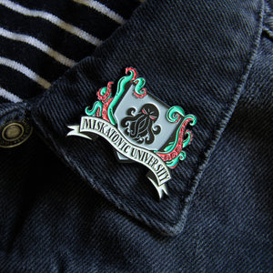 A cool lapel pin of the Miskatonic University crest, featuring Cthulhu. 
