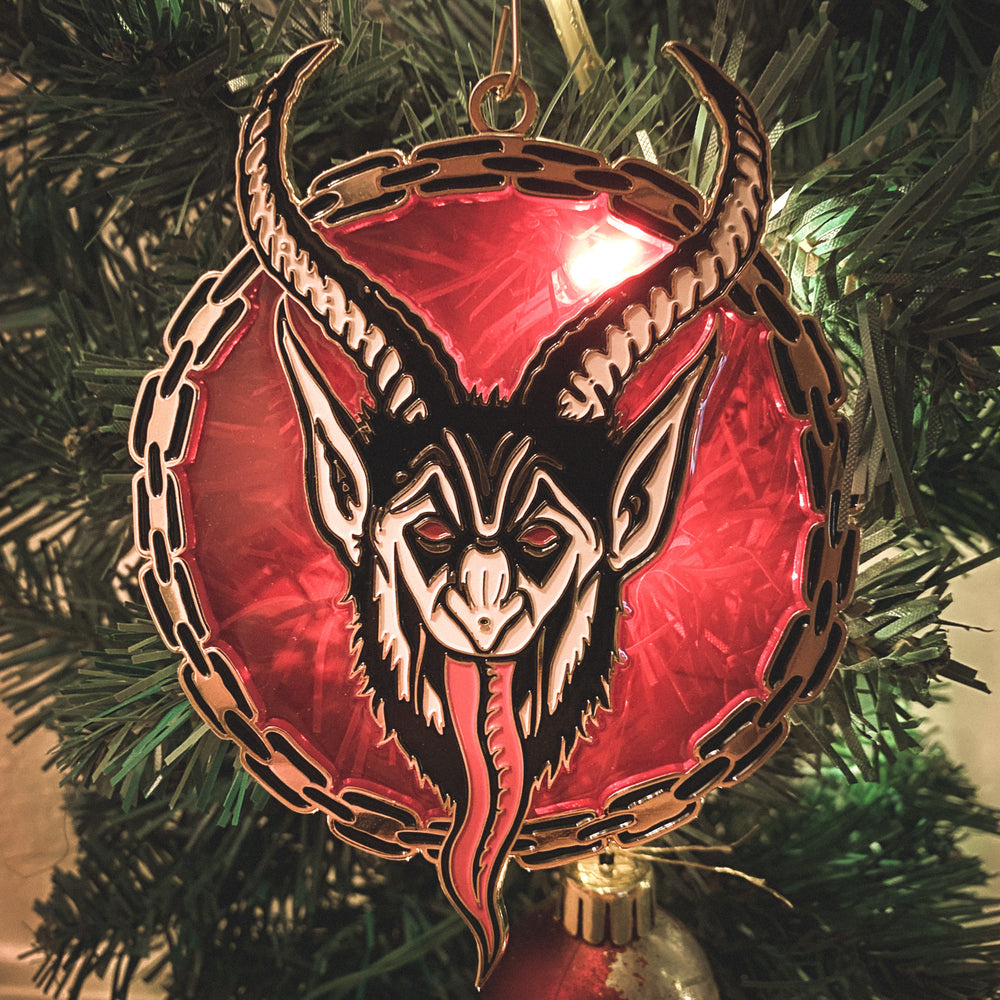 A red and gold Krampus enamel Christmas ornament designed by Ectogasm.