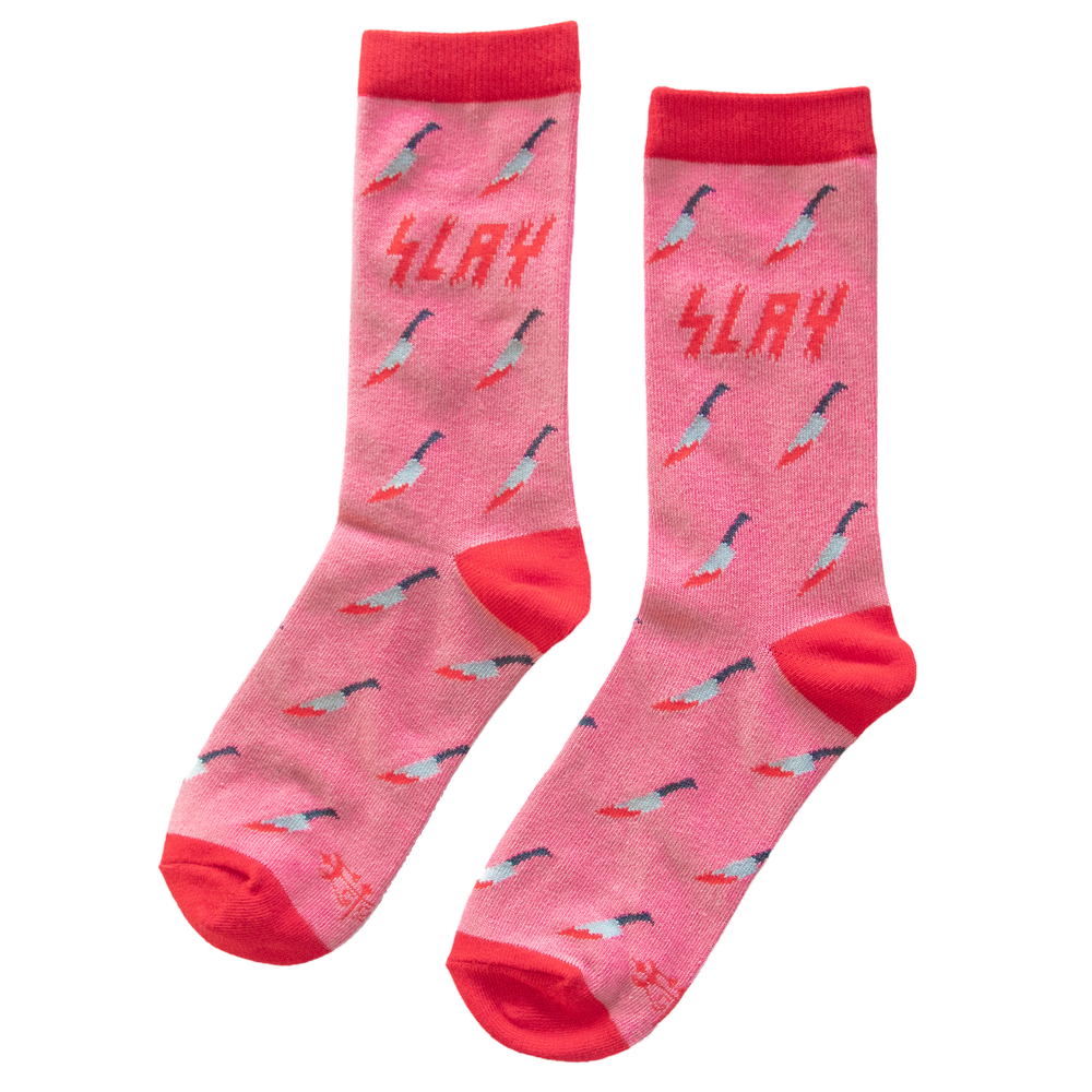 Ectogasm pink and red crew socks that have a pattern of horror movie inspired bloody kitchen knives on them. The top of the socks has the quote, "Slay". 
