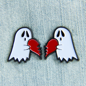 A cute enamel pin set for couples of two ghosts holding a heart. 