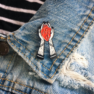 A cool lapel pin of witchy hands holding a heart on a jean jacket. Made for women's punk style. 