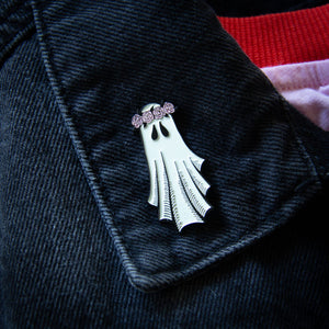 An enamel pin for women of a sheet ghost wearing a crown of roses. 