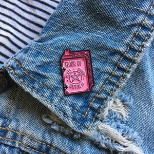 A creepy cute, pink badge of a witch's spell book for pastel goth fashion. 