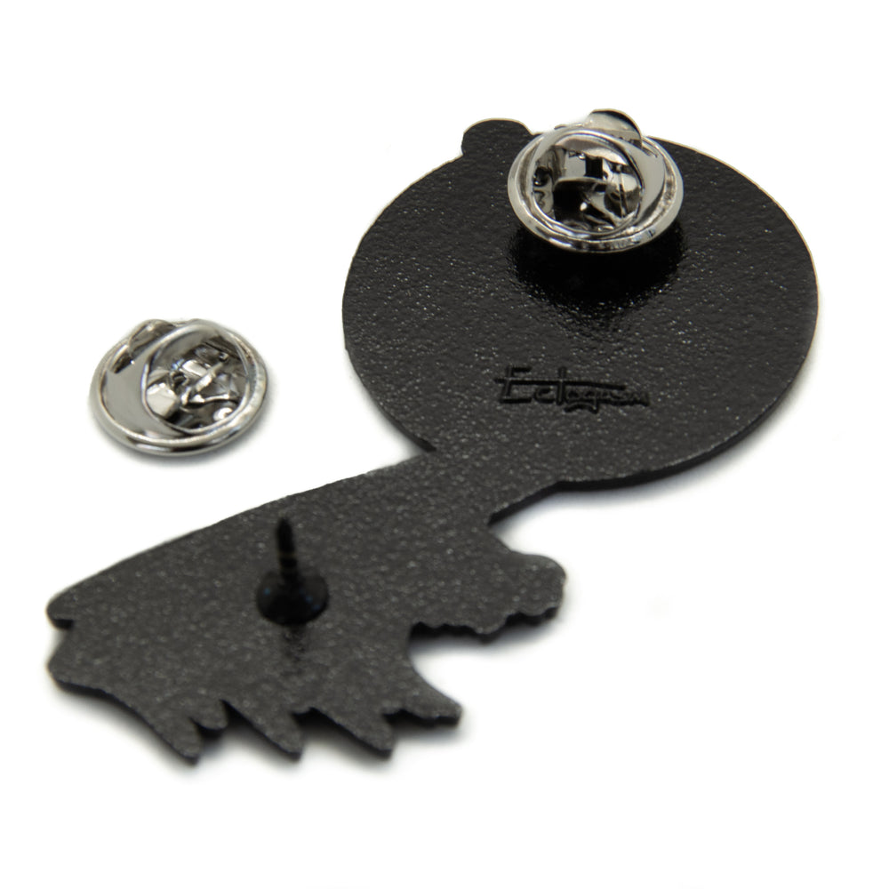 Metal clasps on the back of a large enamel pin for unisex punk fashion.