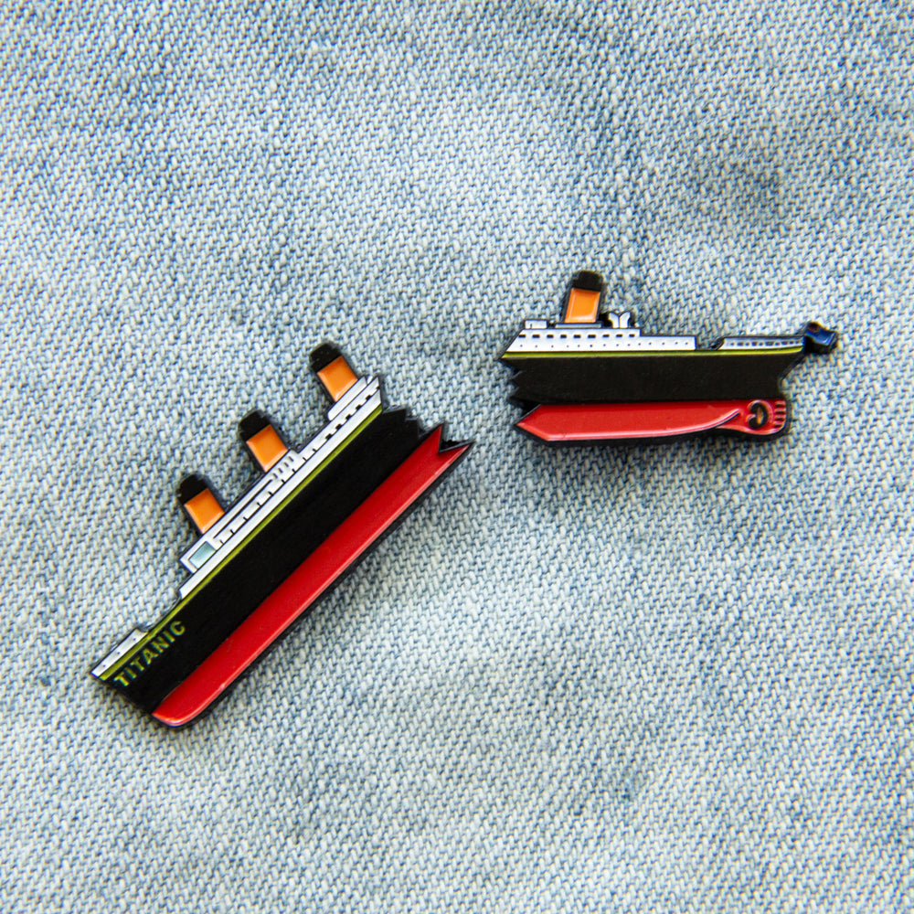 A set of enamel pins that feature RMS Titanic in two broken halves. 