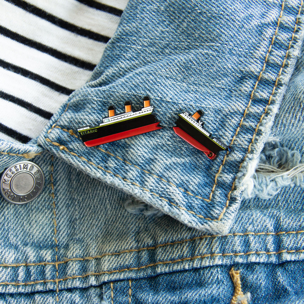 A nautical pin of RMS Titanic, sinking into the ocean. Pictured on the lapel of a denim jacket. 